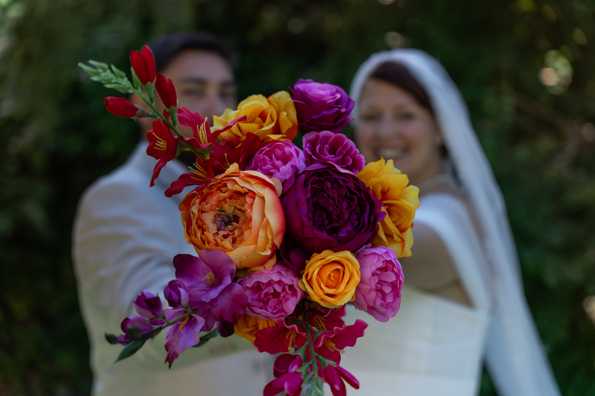 focus-bouquet-mariee-fleurs-multicolores-flou-arriere-plan